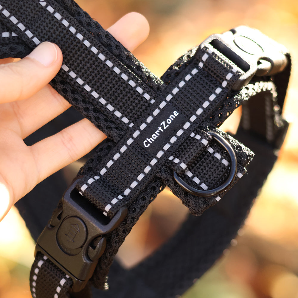 Szelki dla charta z odblaskowymi paskami, dopasowane do smukłej sylwetki psa, wykonane z lekkiego, oddychającego materiału, w kolorze czarnym z elementami odblaskowymi dla lepszej widoczności po zmroku.